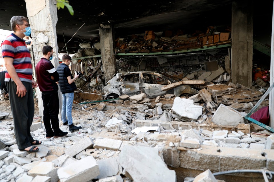 People inspect the rubble of destroyed residential building  hit by Israeli airstrikes