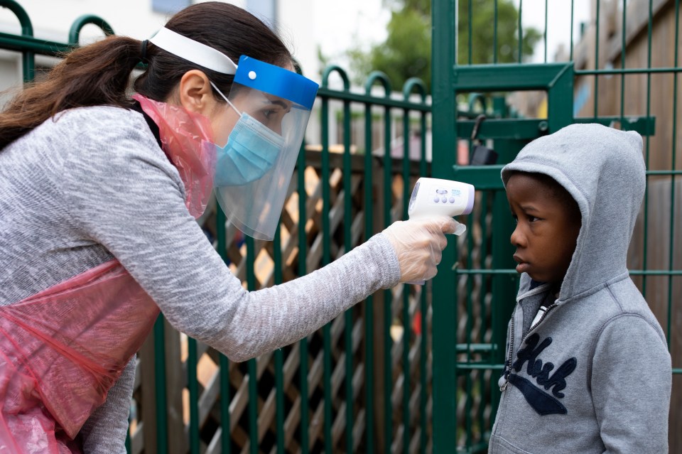 A member of staff takes a child's temperature at the Harris Academy's Shortland's school in London