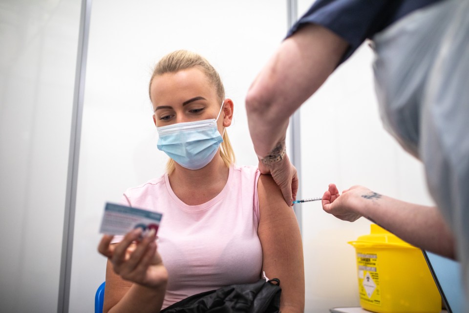 A woman in Darwen, Lancs, receives a Covid-19 vaccine inside a pharmacy