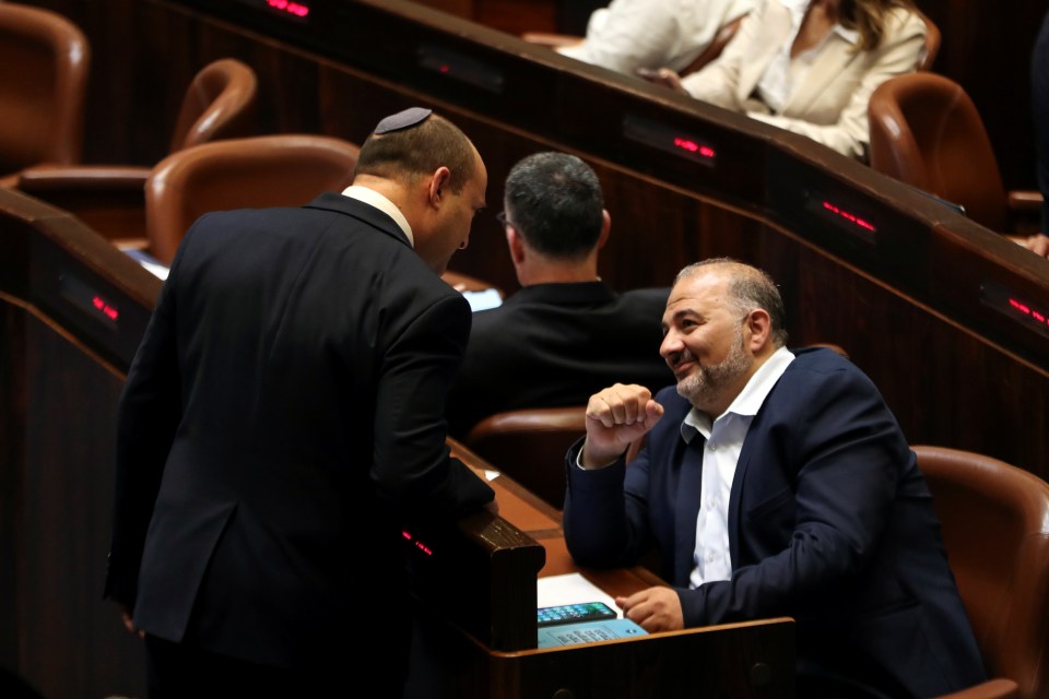 Naftali Bennett, pictured chatting during a special session of Israel's parliament today, will become the next prime minister