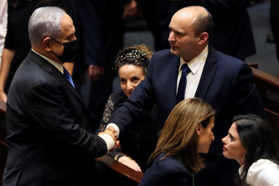 Netanyahu and Bennett shake hands following the vote