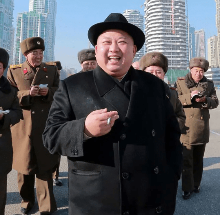 Chain smoking Kim clutches a cigarette while inspecting housing blocks in January 2017