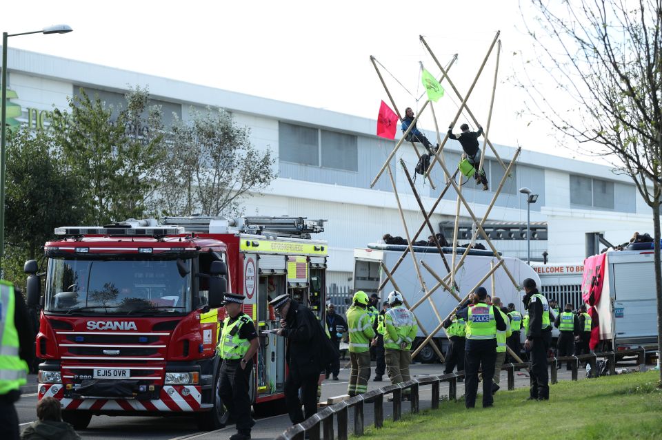 Police and fire services outside the Newsprinters printing works while protesters use bamboo lock-ons and vans to block the road