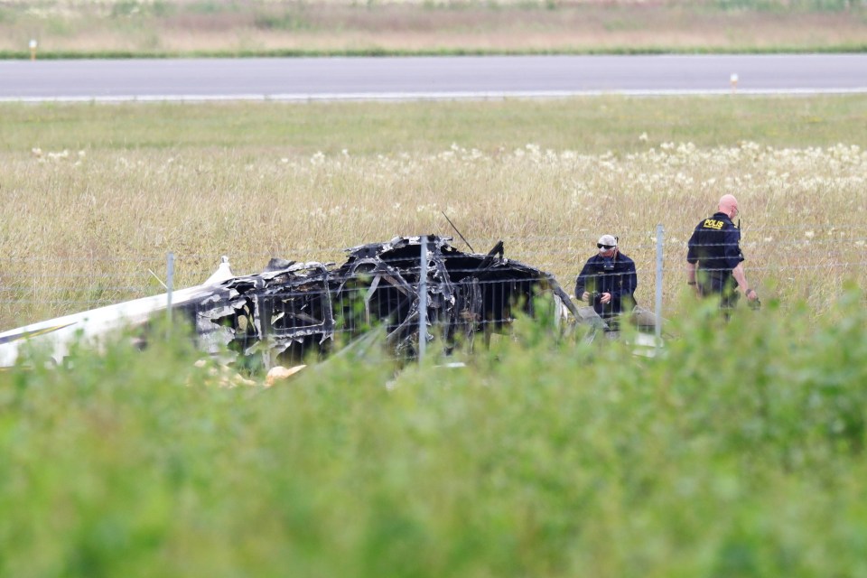 Police officers investigate the plane wreck outside Orebro Airport