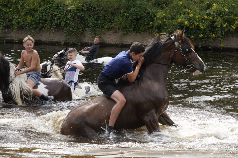 Children ride horses in the River Eden in Appleby