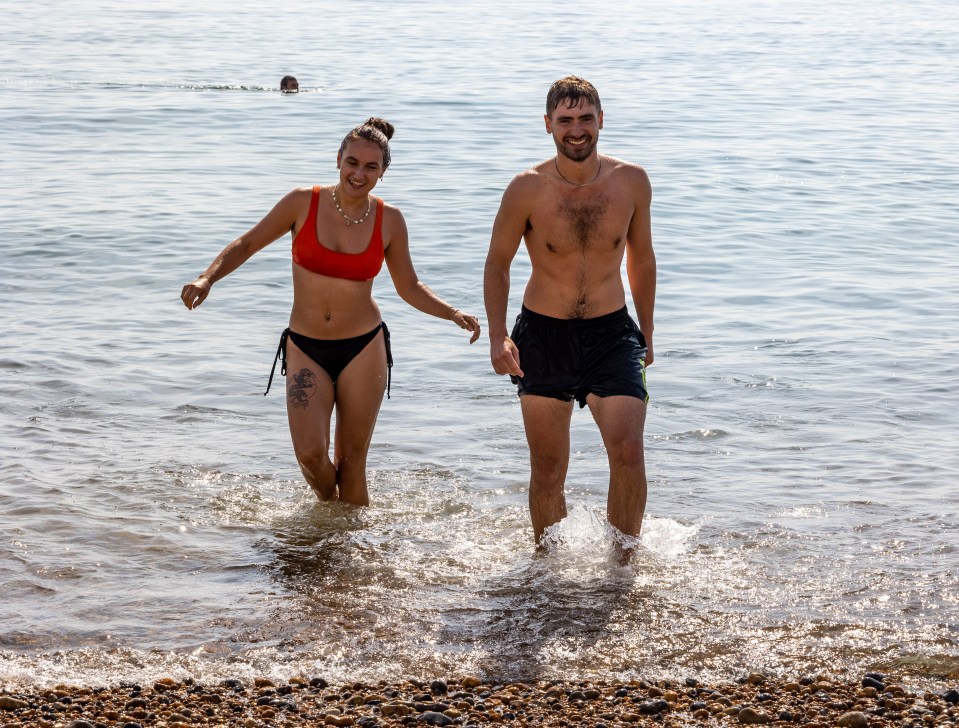 Swimmers Oscar Stelzer-Hiller and Ella Powles cool off with a splash in Brighton Beach, East Sussex