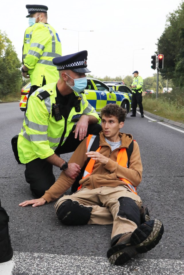 One man lies on the road surrounded by police