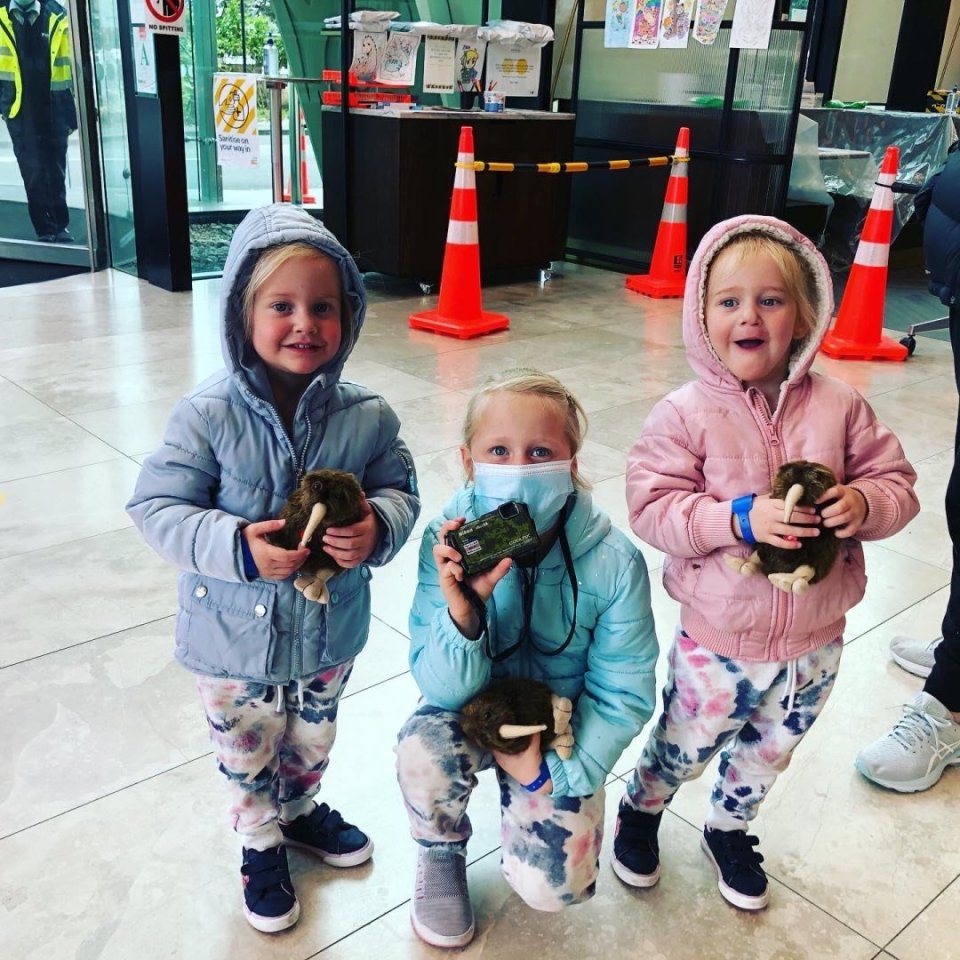 Liane Dickason, six, and twins Maya and Karla, two, smile after landing in New Zealand on August 30