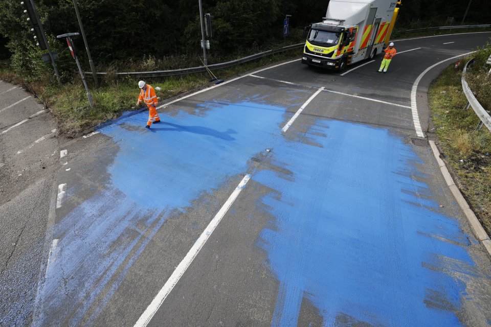 Highways England workers clear up after blue paint was spilt on the motorway at junction 9 of the M25 in Leatherhead