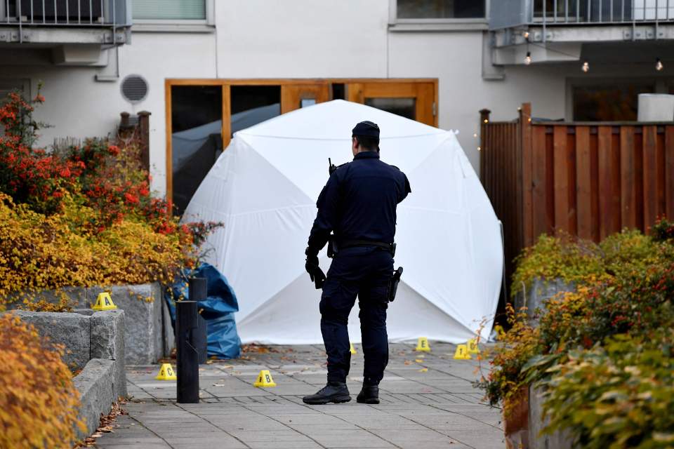 A police officer stands next to a crime scene at the Hammarby Sjostad district in Stockholm where Einar was shot