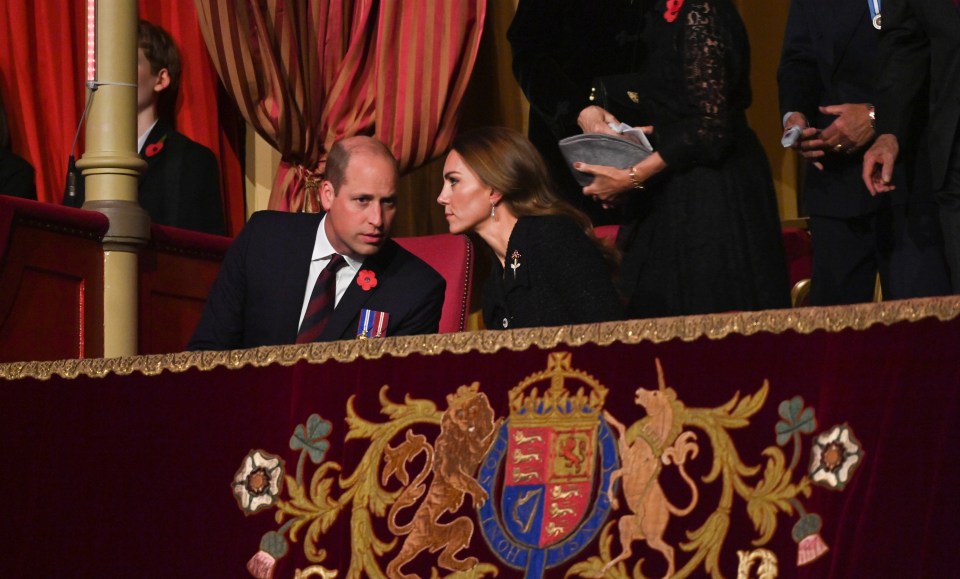 Prince William and Kate Middleton share a quiet word between performances