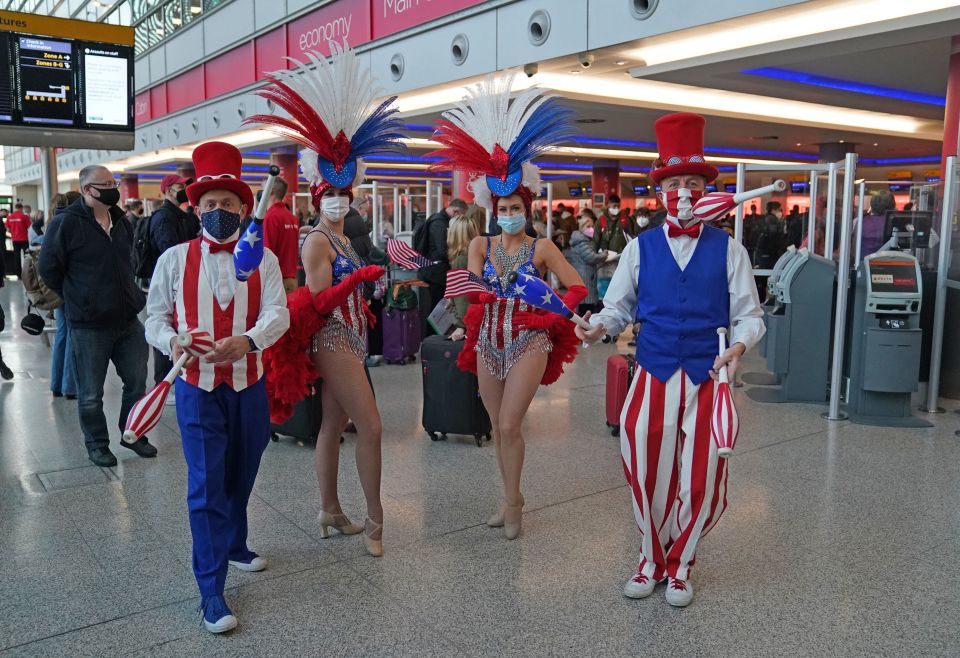 Performers entertain passengers at London Heathrow Airport's T3 as the US reopens its borders to UK visitors