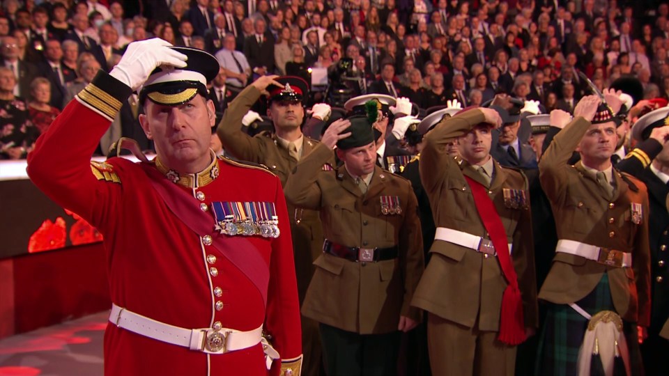 Hats and berets are removed to show respect to the fallen