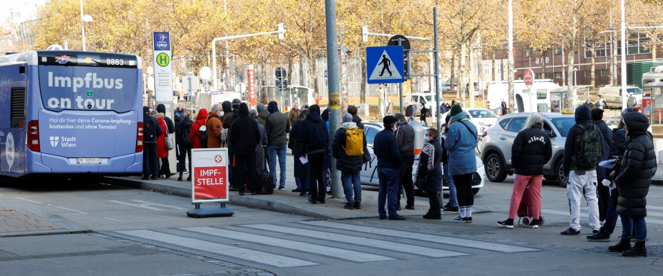 People wait in front of a vaccination bus after Austria imposed a lockdown on unvaccinated people