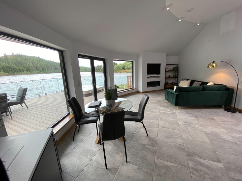 The circular wooden lodge is on the edge of a loch
