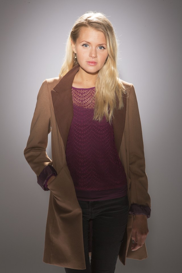 Woman in brown coat and burgundy top.