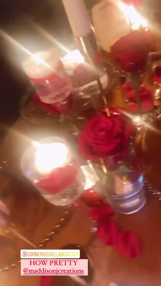 The dining table was decorated with red roses and glass plates