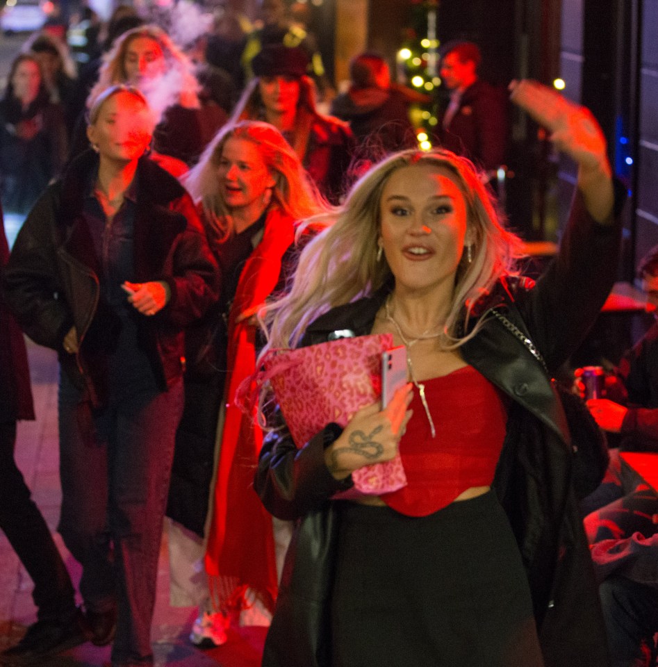A partygoer in London's Soho gives a wave