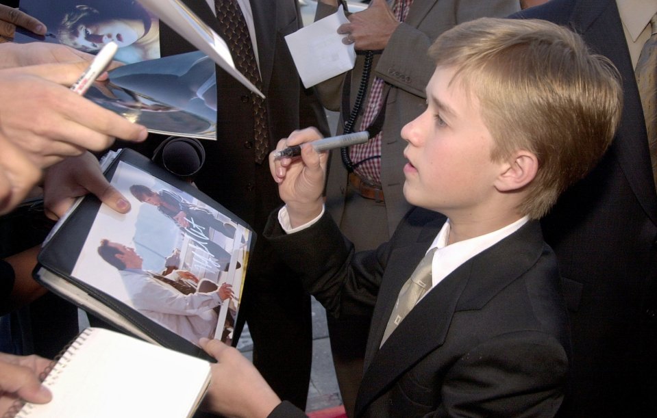 Haley Joel Osment signing autographs.