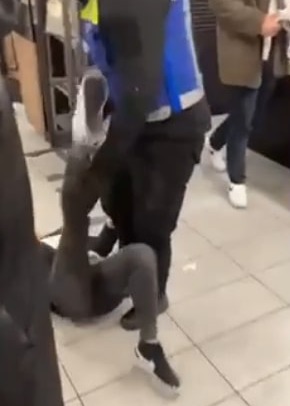 The girl is seen kicking her leg up at the guard's shoulder