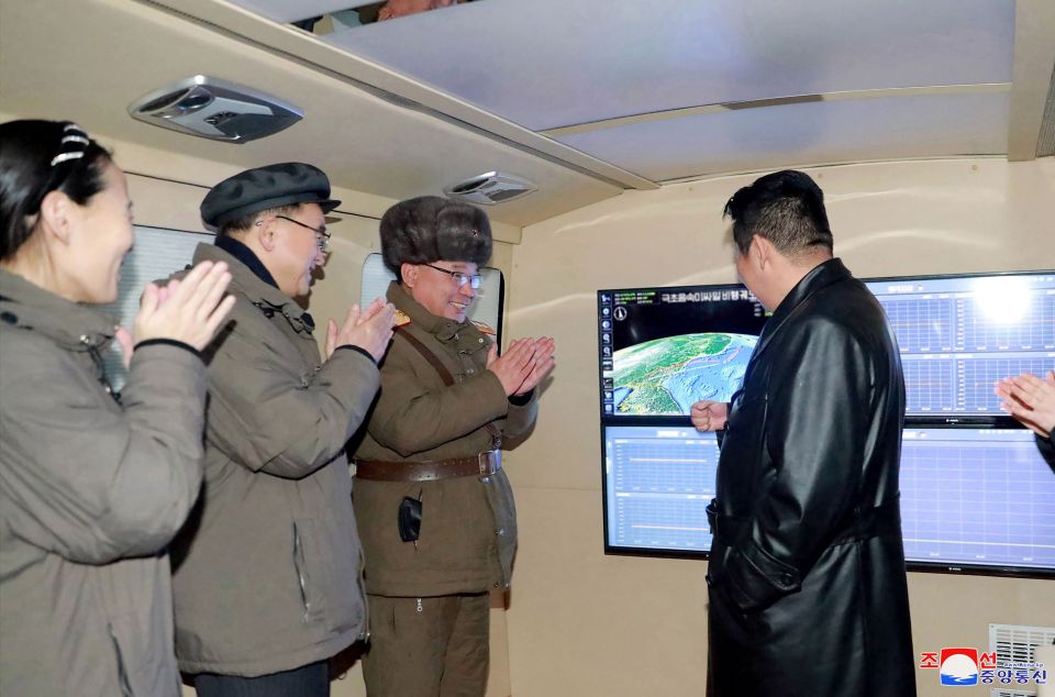 Kim Jong-un beside the screen with his sister on the left
