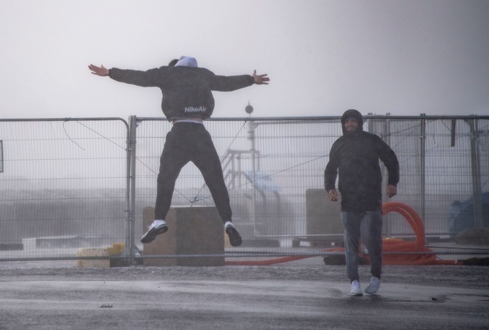 In Southsea, Hampshire, friends were pictured leaping into the air as strong winds hit