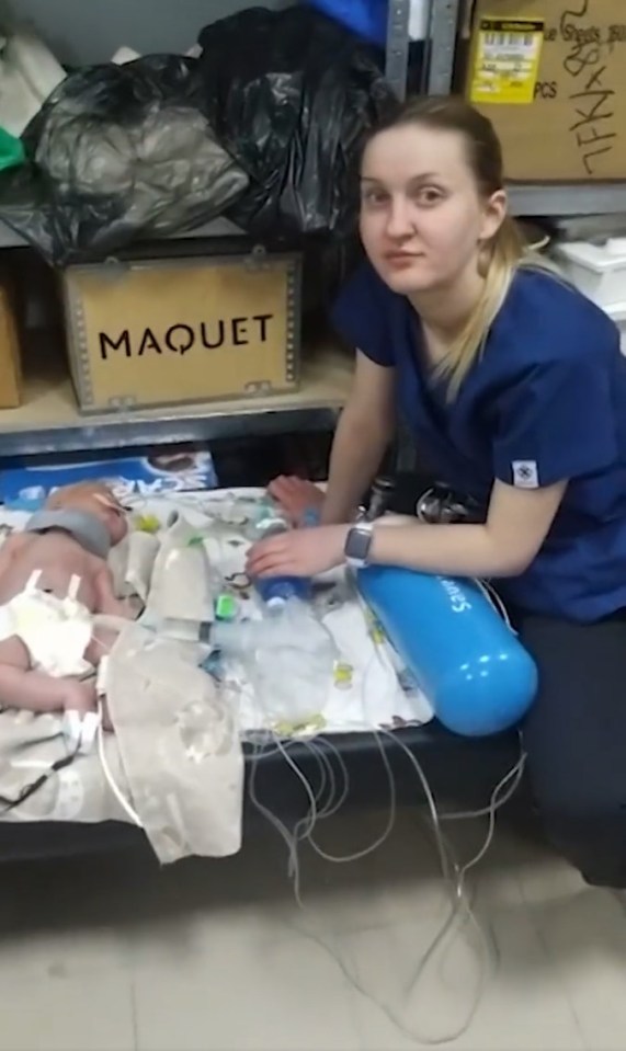 One of the brave nurses with the newborn children in the makeshift shelter