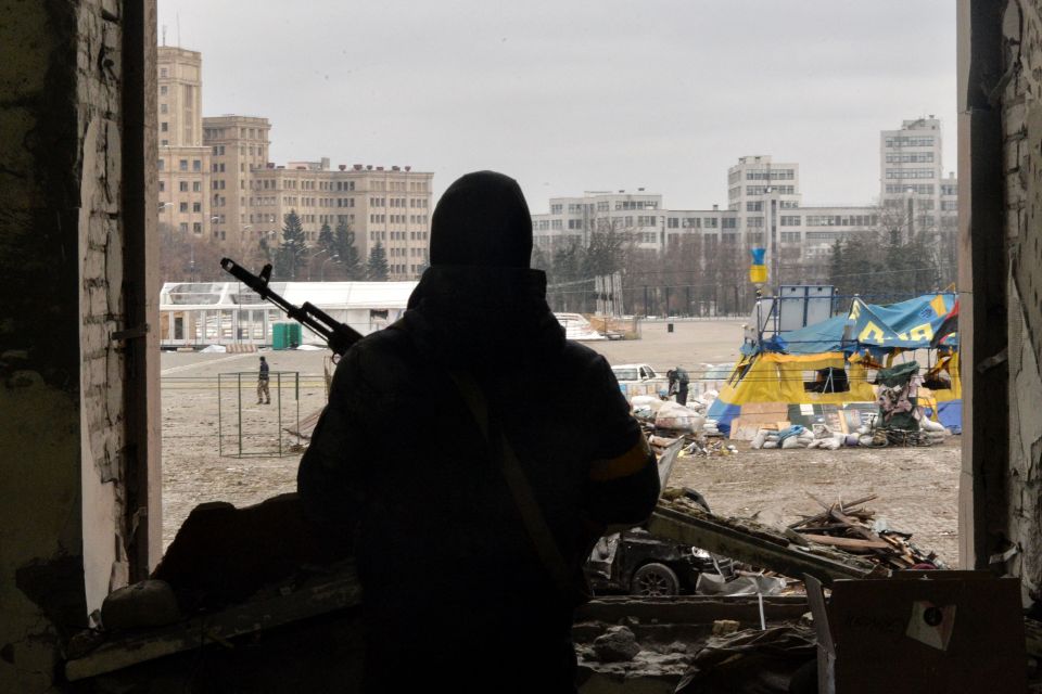 A soldier stands guard in the ruins of Kharkiv