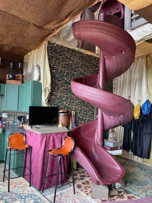 Guests step inside a tent and head down a 12-ft winding slide to enter the property