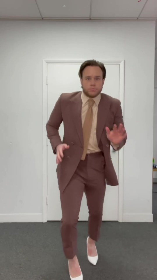 Olly started off his video in a brown suit...