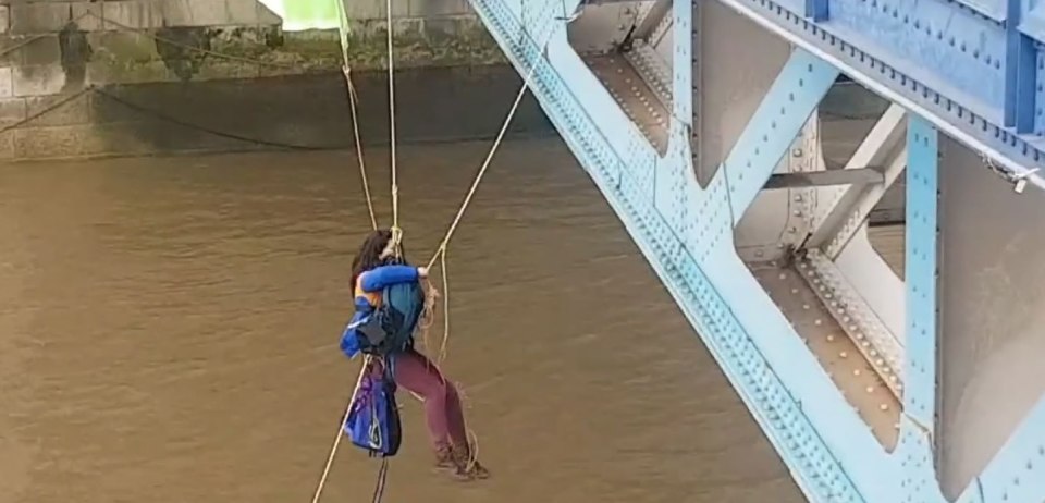 The two demonstrators embrace as they abseil down the landmark