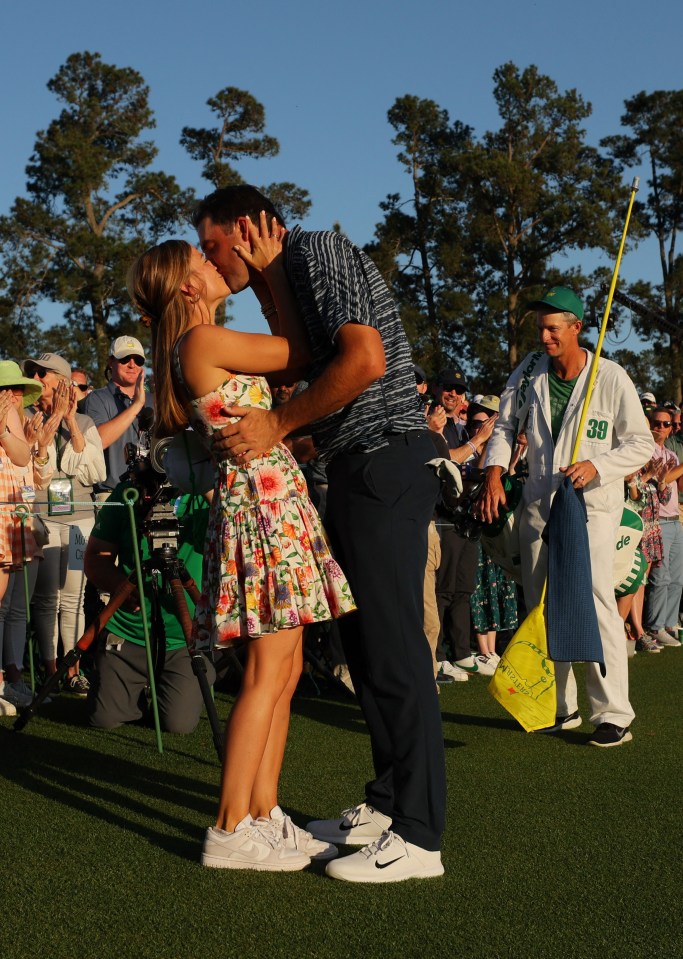 Scheffler celebrates with a kiss from his wife Meredith Scudder