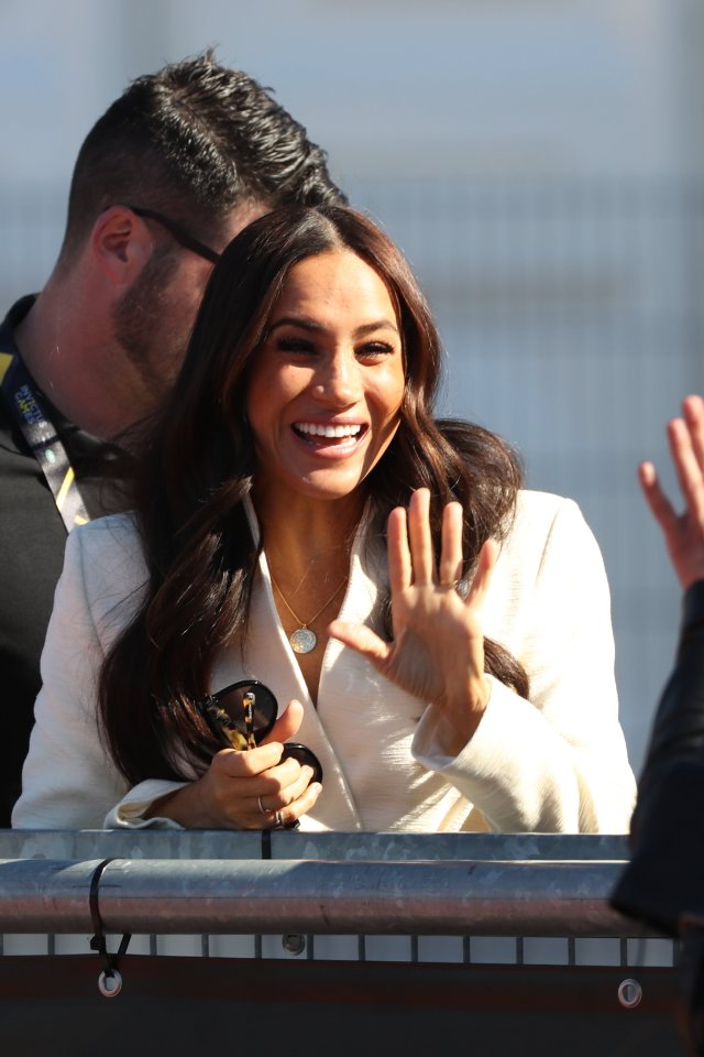 Meghan grins and waves at the athletes