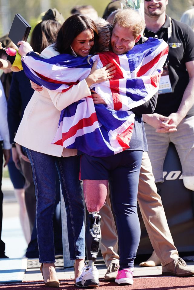 The Duke and Duchess of Sussex hug Team United Kingdom competitor Lisa Johnston