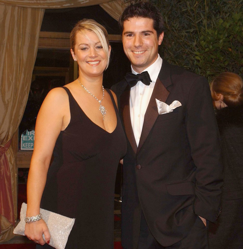 a man and woman are posing for a picture in front of an exit sign