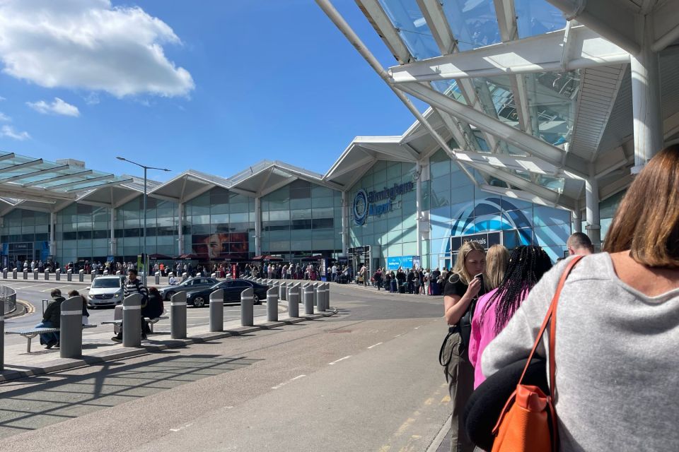 A huge queue of passengers standing outside Birmingham Airport amid ongoing travel chaos