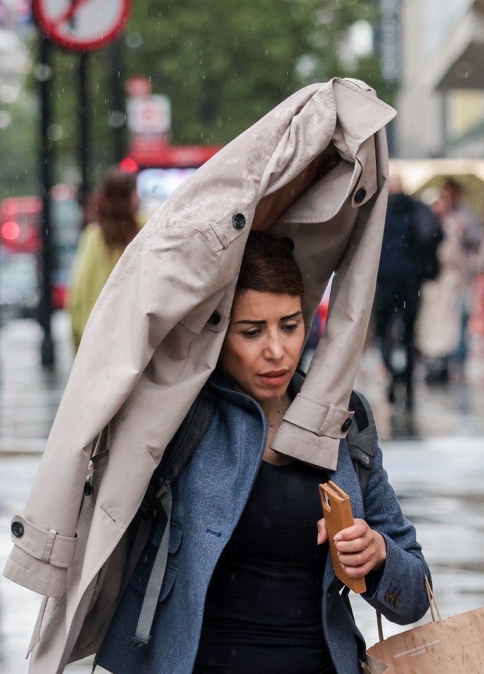 A woman tried to use her coat as a makeshift umbrella