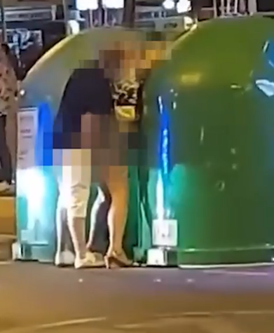 The couple were caught romping up against a bin