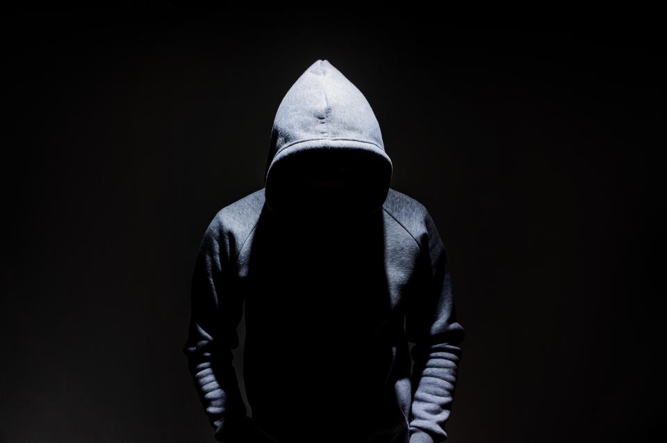 KHERCP Silhouette of man in the hood, dark mysterious man hoodie, murderer, hacker, anonymus on the black background with free space