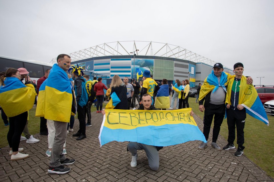 A Ukraine supporter holds a flag bearing the name of his war-torn home city.