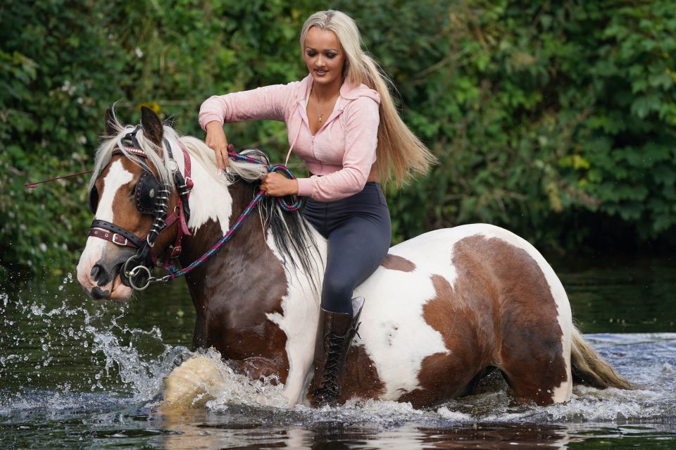 A woman rides her horse through the rivers during the festival