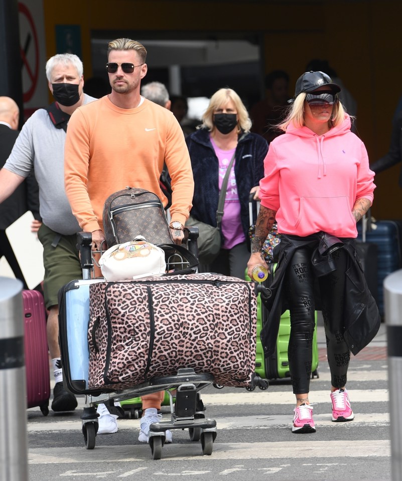 Katie Price couldn't be missed in a bright pink hoodie as they arrived at the airport