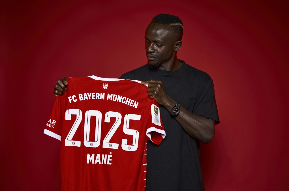 Mane holds up a Bayern Munich shirt after completing his transfer