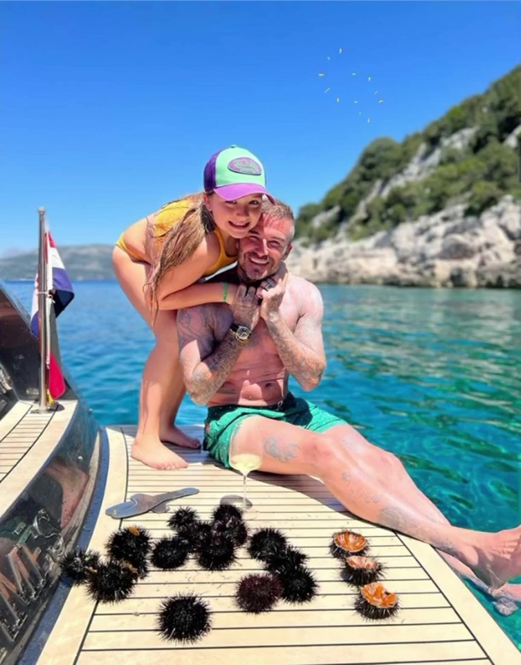 David hugged daughter Harper as they relaxed on the side of a boat