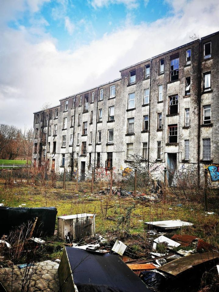 Abandoned apartment building with debris in the foreground.