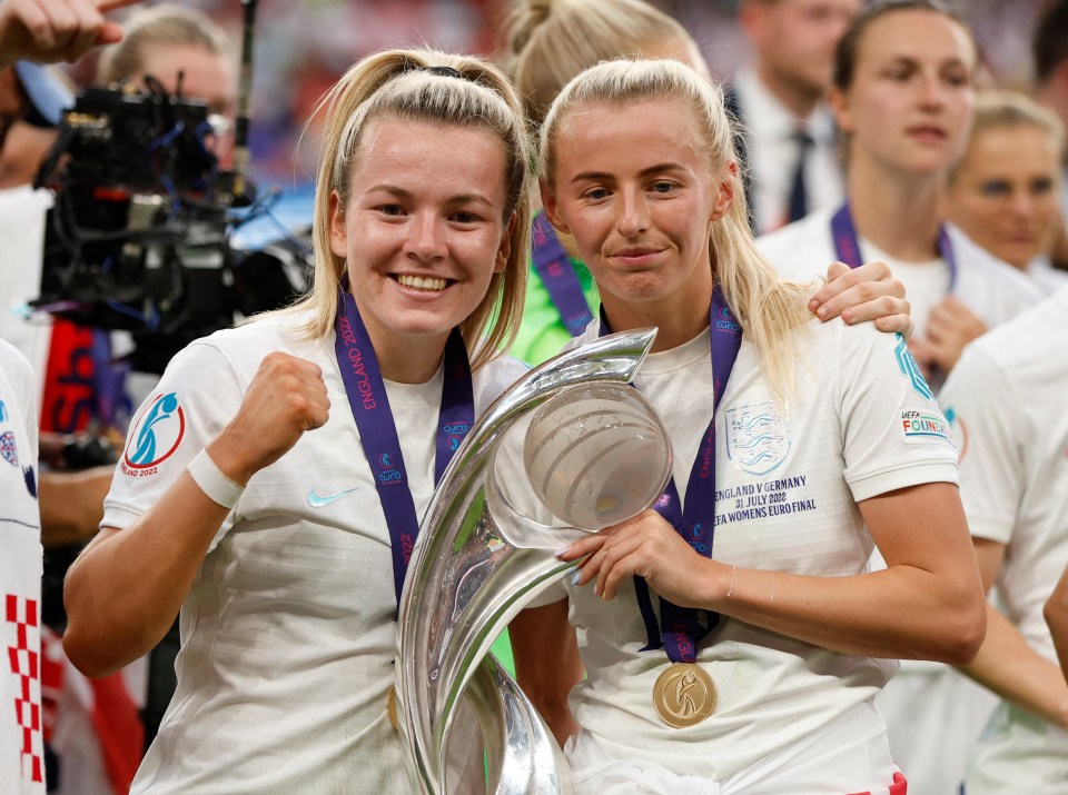 Kelly, left, lifts the European Championship trophy alongside Lauren Hemp