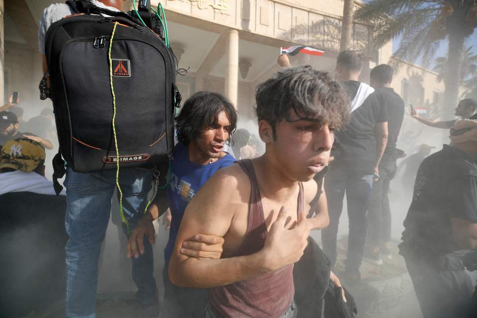 Supporters Sadr react to smoke outside the capital Baghdad’s Green Zone