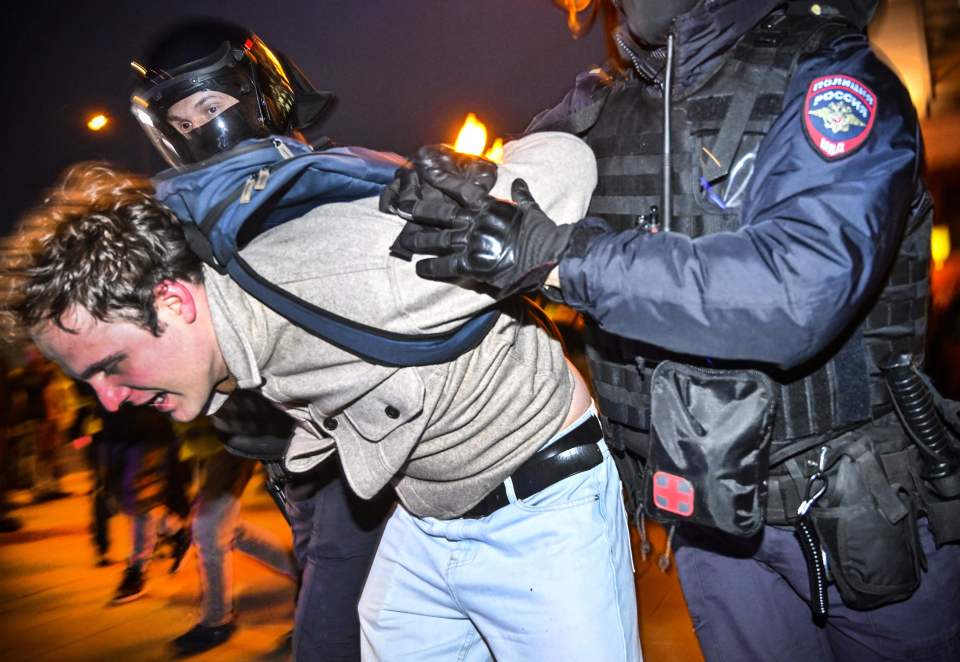 Police officers detain a man protesting the mobilisation in Moscow