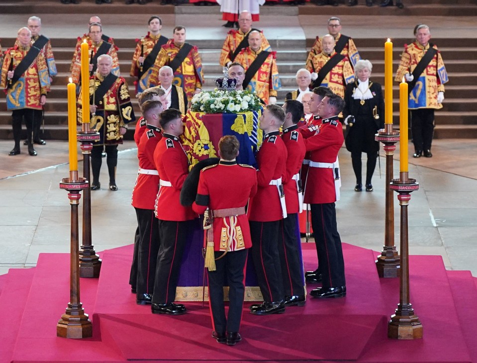 The Bearer Party from Queen's Company, 1st Battalion Grenadier Guards, place the coffin of Queen Elizabeth II on the catafalque at Westminster Hall