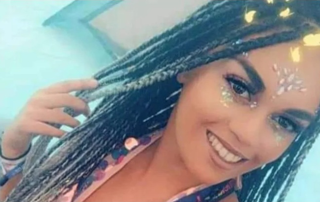 a woman with dreadlocks and glitter on her face is smiling for the camera .